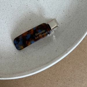 Detail of French acetate hair clip with tortoiseshell texture on a ceramic dish