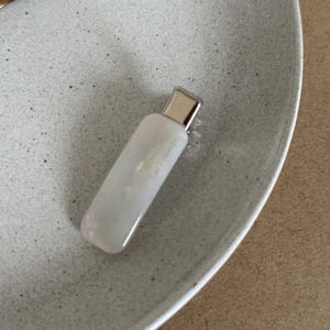 Detailed close-up of a white acetate hair clip with Barrette La France engraving