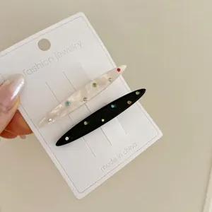 Ensemble élégant de barrettes en acétate noir et blanc marbré avec strass colorés brillants
