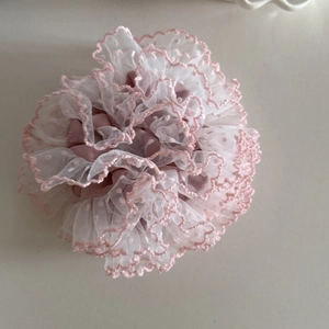 Detail of layered white mesh scrunchie with pink embroidered dots and wavy edges