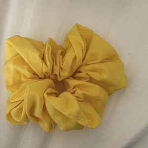 Detailed close-up of a large yellow scrunchie made from high-quality textured linen fabric