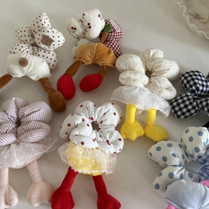 Floral and checkered plush scrunchies with cute stuffed limbs on white background