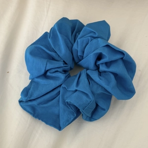 Detailed view of dark blue fabric scrunchie texture with elastic inner band for hair
