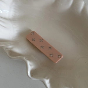 Sparkling pink acetate hair clip with rhinestone star pattern on elegant shell tray