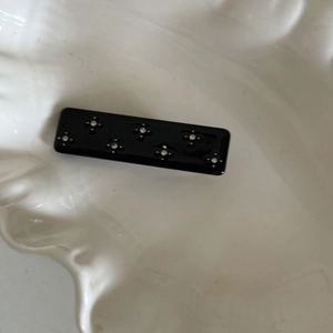 Elegant black acetate rectangular hair clip with silver flower patterns and sparkling crystals