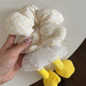 Close-up of duck themed scrunchie with yellow polka dots and white mesh skirt