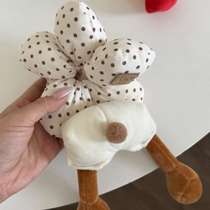 Close-up of plush bear claw hair scrunchie with polka dot pattern and soft faux fur detail