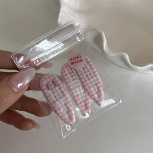 Close-up of pink gingham wave-edged hair clips in hand-made gift packaging