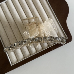 Pince à cheveux élégante avec nœud en tulle crème et strass gris sur plateau bijoux