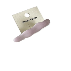 Lavender wavy metal hair clip with glossy enamel finish on a beige display card