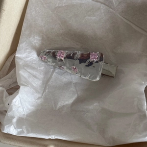 Silberne Haarklammer mit Hammerschlag-Struktur und rosa Kristallen auf weißem Papier