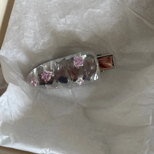 Detailansicht einer blauen Haarspange aus Harz mit quadratischen rosa Kristallen und Metall