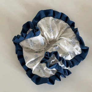 Close-up of blue floral scrunchie with silk fabric and contrast ruffle edge detail