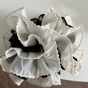 Detailed view of layered polka dot scrunchie with lace edges and pleated chiffon fabric