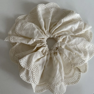 Détails du tissu en coton avec broderie anglaise délicate et bords festonnés sur le chouchou