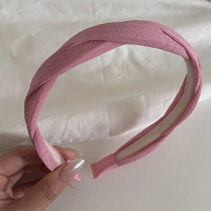 Detail of pink twisted headband with pleated texture and internal non-slip tooth comb