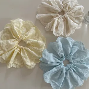 Trois chouchous géants crème, jaune et bleu avec bordure en dentelle délicate