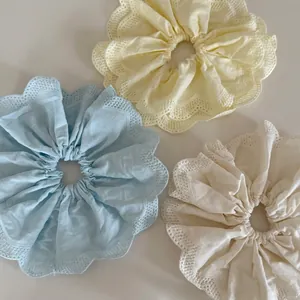 Trois chouchous XL en jaune pastel, bleu et crème avec bordures en dentelle fine
