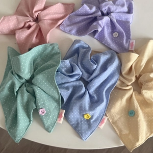 Detail of colorful polka dot bow hair ties with floral buttons and handmade labels