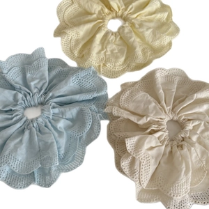 Trois chouchous géants en dentelle pastel aux couleurs crème, bleu clair et blanc