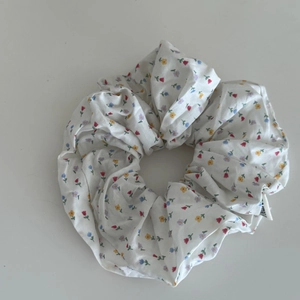 Detailed close-up of floral scrunchie with colorful patterns and soft fabric texture
