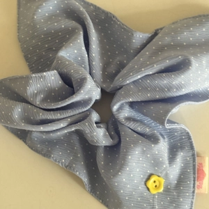 Light blue polka dot scrunchie with a yellow flower button and handmade label