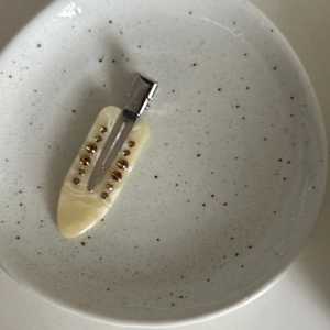 Makro-Detail der Haarspange aus Acetat mit Marmormuster, Bernsteinsteinen und Silber-Metallclip