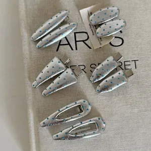 Silver hair clip set with blue polka dots on beige canvas background, 10 piece hair clips