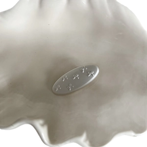 Minimalist oval hair clip with 3D bow embossed patterns in white leather finish