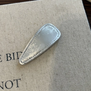 Minimalist silver faux leather triangular hair clip with neat stitching details