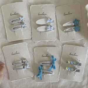 Detail of blue and silver star bow hair clips with faux gems on card display