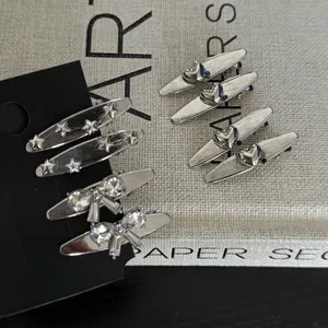 Lot de trois barrettes à cheveux argentées en métal avec nœud et étoile sur carte