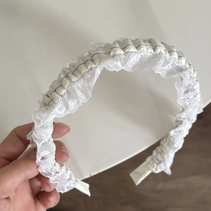 Détail d'un joli serre-tête en tissu rayé bleu clair avec bordure en dentelle blanche