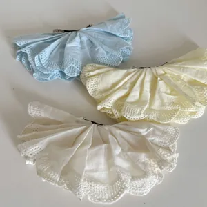 Detailed embroidery on pleated lace spring clips in blue, yellow, and cream white fabric