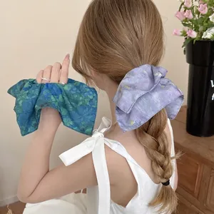 Floral print oversized scrunchies in blue and purple displayed in a vintage scene