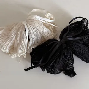 Detailed macro view of delicate lace bow hair clips with soft satin ribbon center
