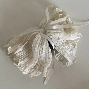 Close-up of vintage beige lace hair comb with ribbon bow and black plastic teeth