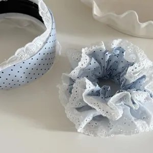 Détail d'un ensemble de coiffure bleu clair à pois avec dentelle blanche et serre-tête