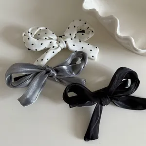 Lot de trois barrettes nœuds avec pois, aspect métallique argenté et satin noir élégant