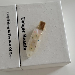 Elegant ivory acetate hair clip with colorful rhinestones on a white gift box