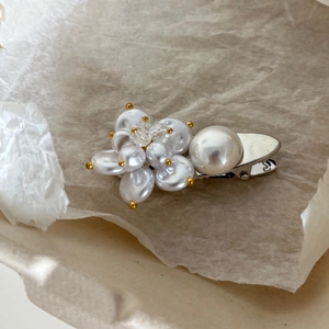 Close-up of elegant floral pearl duckbill hair clip with silver metal base and beads