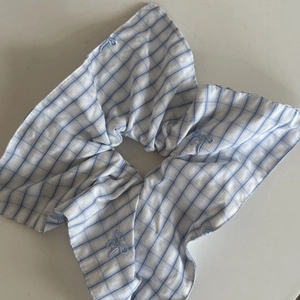 Dettaglio dello scrunchie a righe bianche e blu con ricamo delicato sui bordi