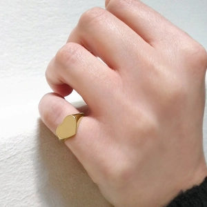 Polished gold heart ring worn on pinky finger as a fashion accessory for women