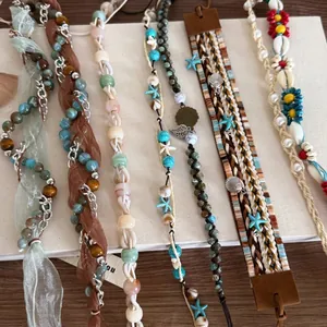 Détail de bandeaux tressés bohèmes et accessoires en coquillage aux tons naturels