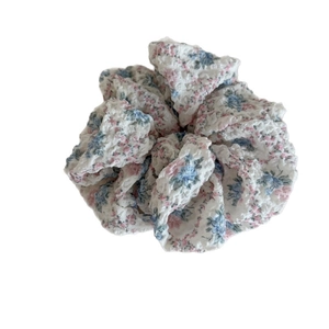 Scrunchie a fiori rosa e blu in tessuto seersucker con una consistenza goffrata