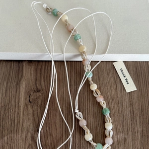 Détail de perles translucides colorées avec cordon blanc pour une sangle de style bohème