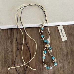 Vue détaillée du collier bohème avec étoiles de mer et perles bleues sur cordes