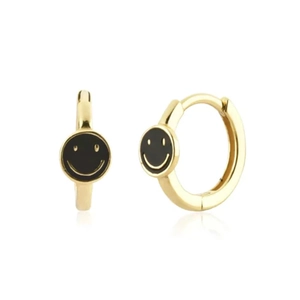 Detail view of gold hoop earrings with yellow smiley face charms on a white background