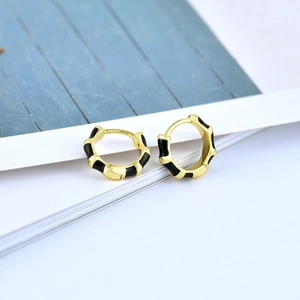 Detail view of bamboo texture hoop earrings with black enamel and gold plating