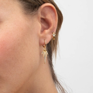 Élégant ensemble de boucles d'oreilles dorées avec étoiles et zircons sur un mannequin